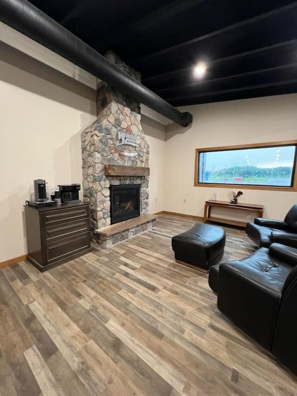 Cozy living room with stone fireplace, wood accents, and modern seating arrangement.