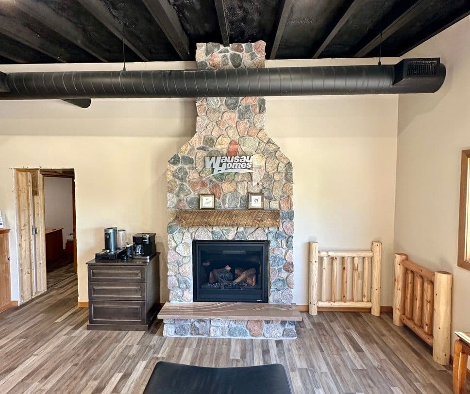 Modern living room with a stone fireplace, sleek furniture, and wood accents. Ideal cozy space.